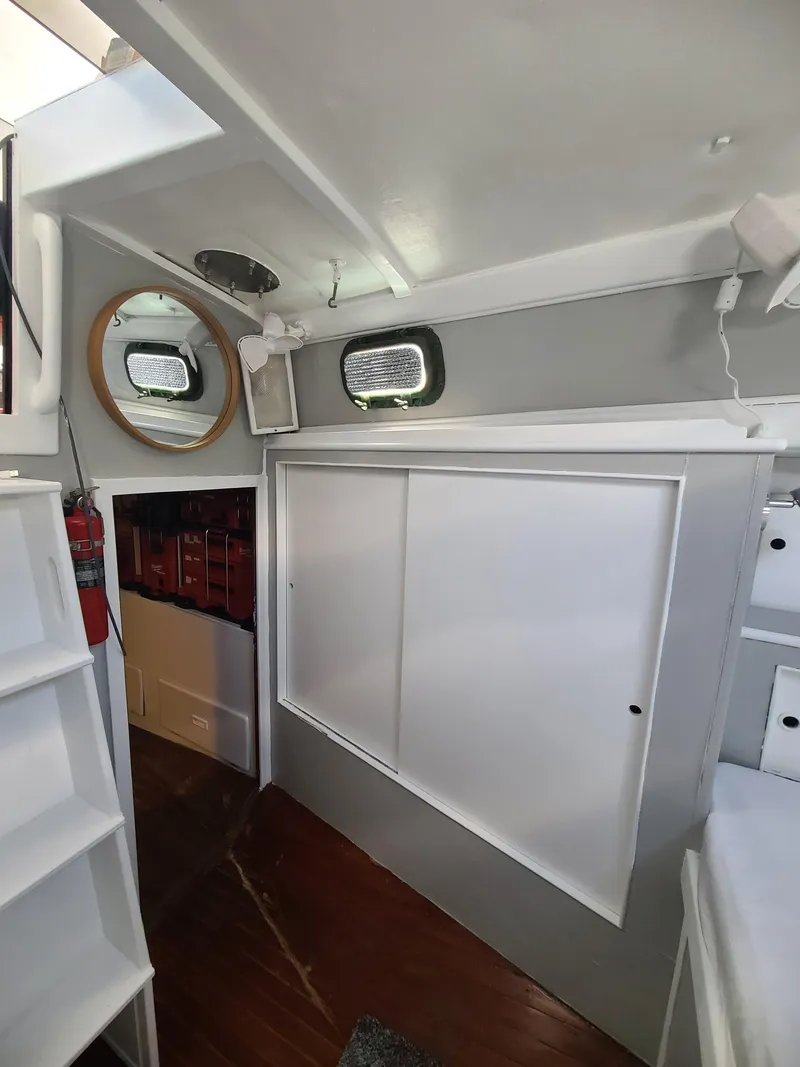 Slide: The Image of Interior of 1981 Kelly Peterson 44 sailboat with wooden floor and white cabinetry. - 45