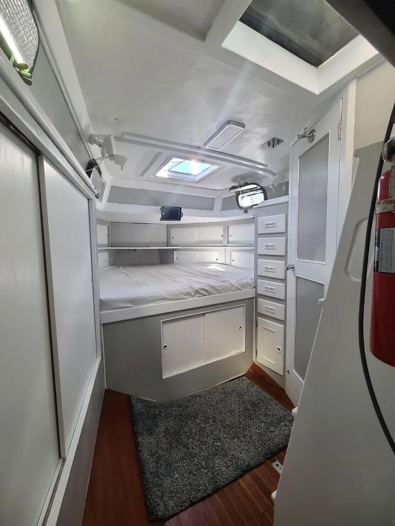 Slide: The Image of Interior of a 1981 Kelly Peterson 44 yacht cabin with bed, storage, and skylight. - 46