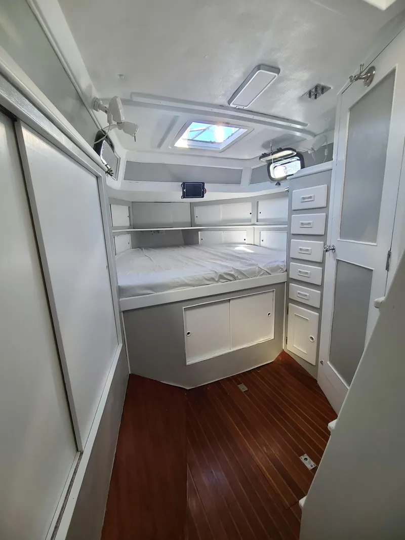 Slide: The Image of Interior of 1981 Kelly Peterson 44 sailboat cabin with bed, storage, and skylight. - 48