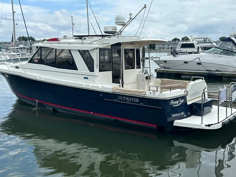 The Image of 2014 Cutwater C-30 Sedan boat docked in a marina, featuring a sleek design and spacious deck. - 1