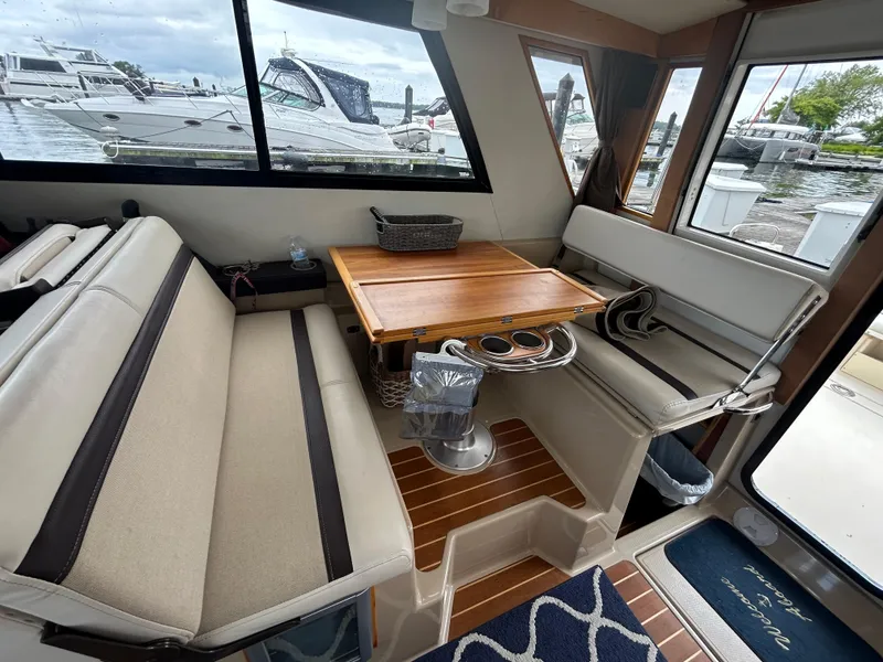 Slide: The Image of Interior of 2014 Cutwater C-30 Sedan with seating and wooden table, docked at marina. - 10