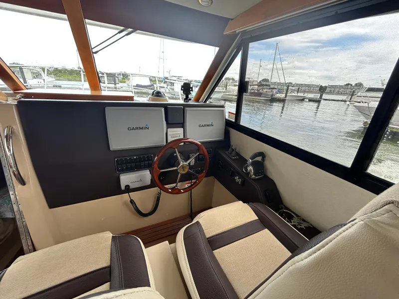 Slide: The Image of 2014 Cutwater C-30 Sedan helm with Garmin navigation, overlooking marina through large windows. - 11