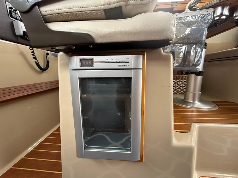 Slide: The Image of Captain's chair and mini fridge in 2014 Cutwater C-30 Sedan boat interior. - 16