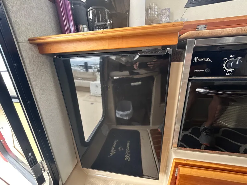 Slide: The Image of 2014 Cutwater C-30 Sedan interior with compact kitchen appliances and wooden cabinetry. - 17