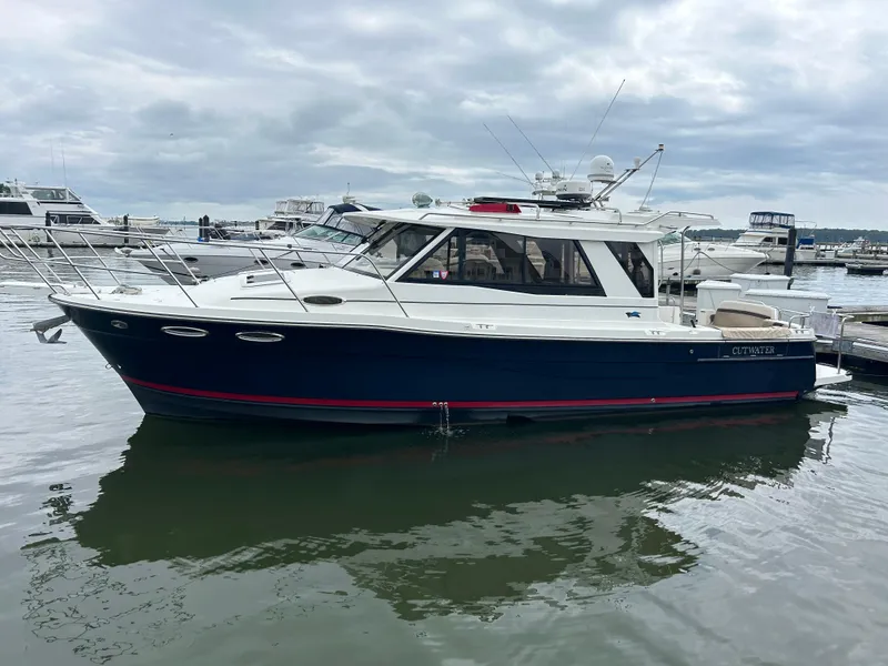 Slide: The Image of 2014 Cutwater C-30 Sedan boat docked in a marina under cloudy skies. - 22