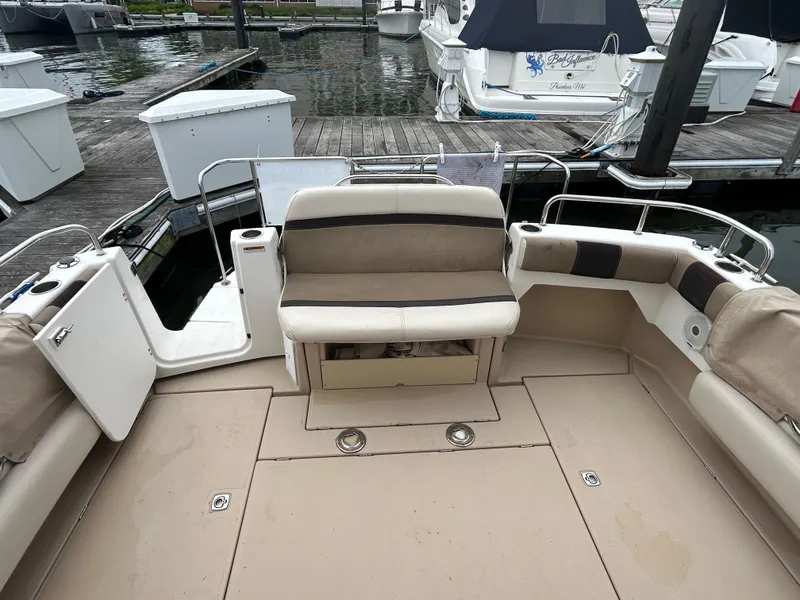 Slide: The Image of 2014 Cutwater C-30 Sedan boat interior with beige seating at a marina dock. - 4