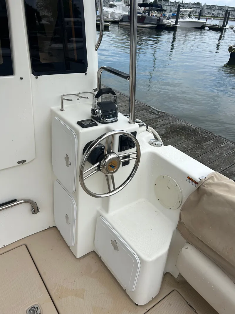 Slide: The Image of 2014 Cutwater C-30 Sedan helm station with steering wheel, docked by the water. - 7