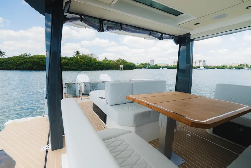 Slide: The Image of 2024 Saxdor 400 GTO boat interior with seating and table, overlooking serene water. - 15