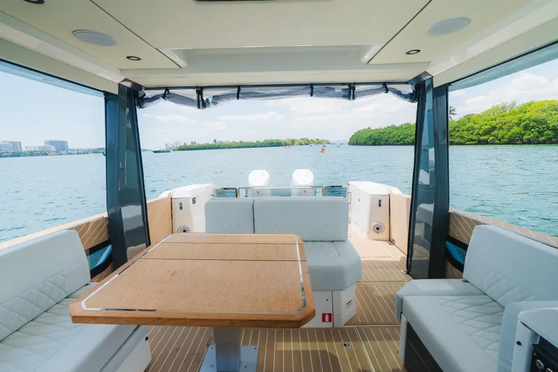 Slide: The Image of 2024 Saxdor 400 GTO interior with seating and table, overlooking serene water and lush greenery. - 25