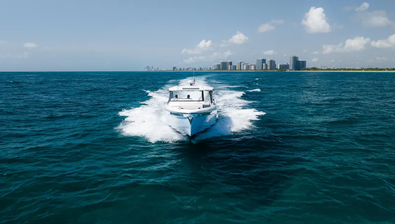Slide: The Image of 2024 Saxdor 400 GTO cruising on open sea with city skyline in background. - 38