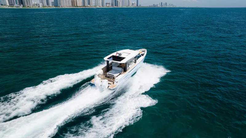 Slide: The Image of 2024 Saxdor 400 GTO cruising on open water near a city skyline. - 42