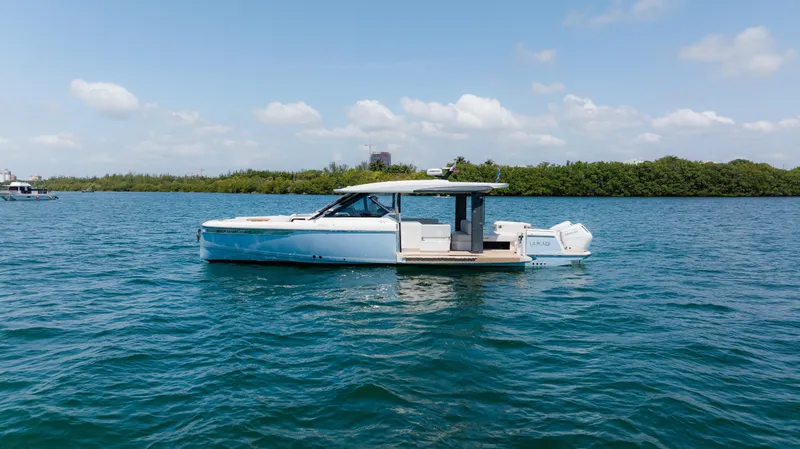 Slide: The Image of 2024 Saxdor 400 GTO boat on calm water under a clear blue sky. - 49