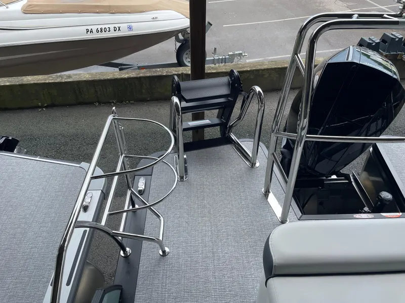 Slide: The Image of 2025 Harris SUNLINER 230 SLDH boat deck with stainless steel railings and motor. - 8