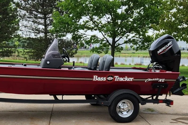 Slide: The Image of 2021 Tracker Bass Tracker Classic XL boat with Mercury engine, parked near a lake. - 4