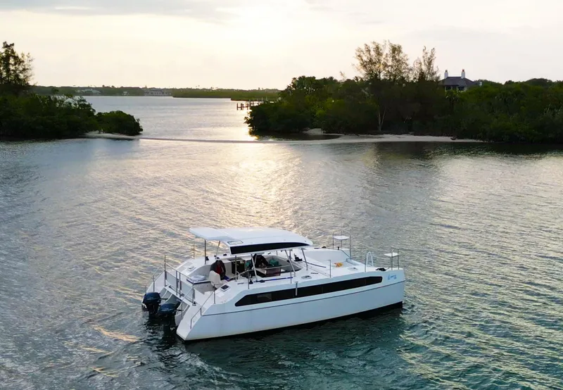 Slide: The Image of 2025 Smart Cat E280 Electric boat cruising on serene waters at sunset. - 7