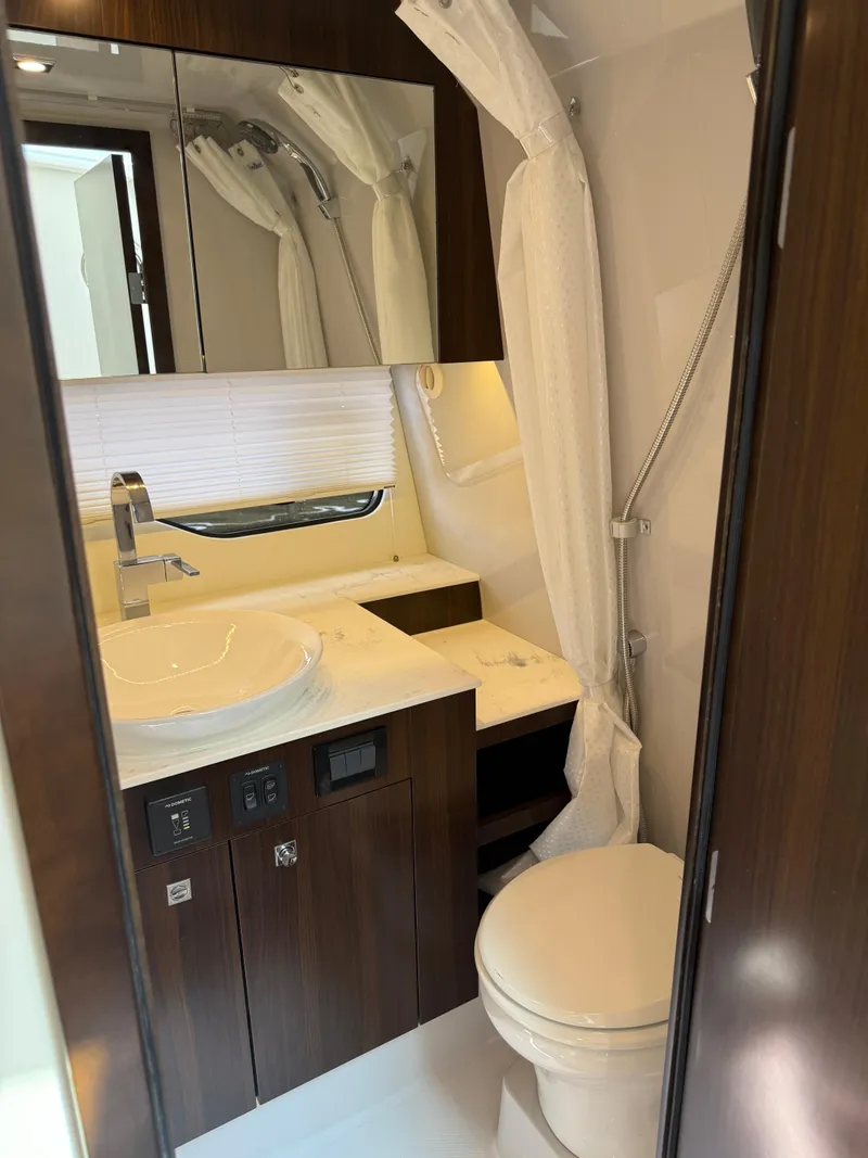 Slide: The Image of 2021 Cruisers Yachts 38 GLS OB bathroom with modern fixtures and wood accents. - 18