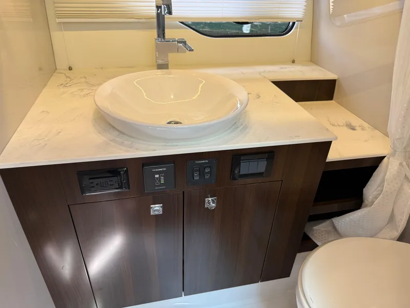 Slide: The Image of 2021 Cruisers Yachts 38 GLS OB bathroom with modern sink and wooden cabinetry. - 19