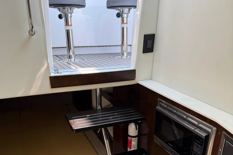 Slide: The Image of Interior view of 2021 Cruisers Yachts 38 GLS OB, featuring stairs and a microwave. - 40