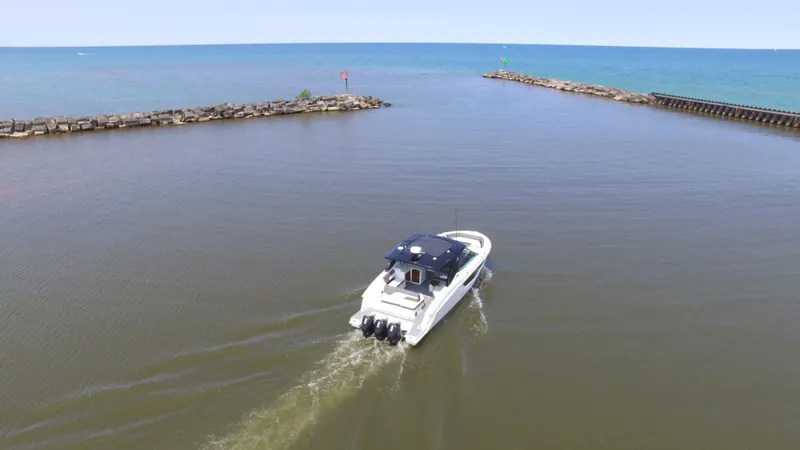 Slide: The Image of 2021 Cruisers Yachts 38 GLS OB navigating a calm waterway towards open sea. - 46