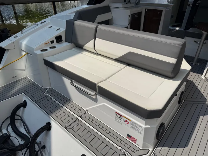 Slide: The Image of 2021 Cruisers Yachts 38 GLS OB boat seating area with gray and white cushions. - 5