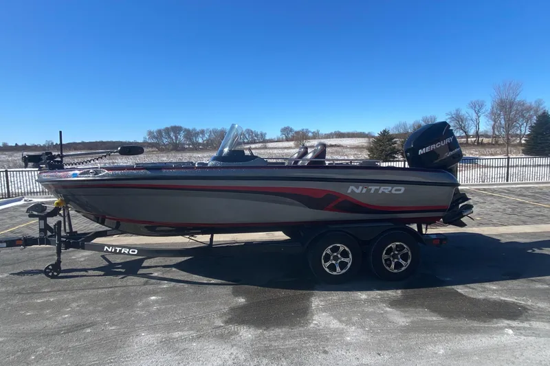 The Image of 2018 Nitro ZV 18 boat on trailer, parked outdoors under clear blue sky. - 0