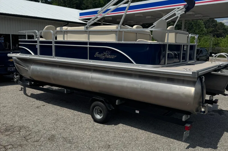 Slide: The Image of 2014 SunChaser Classic Cruise 8520 pontoon boat on trailer at a gas station. - 1