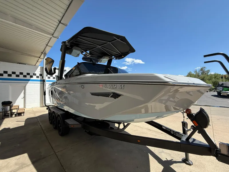 Slide: The Image of 2023 Nautique Super Air G23 boat on trailer under a canopy, sunny day. - 4