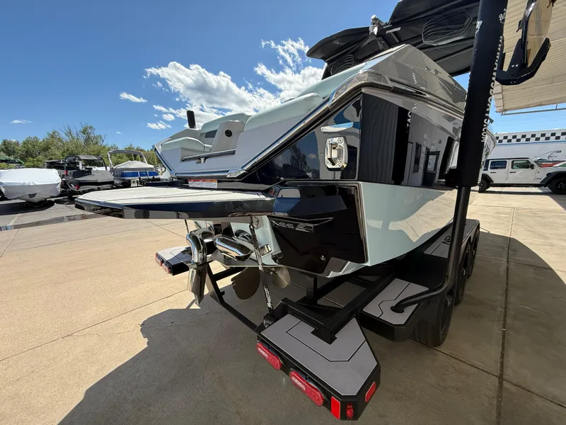 Slide: The Image of 2023 Nautique Super Air G23 boat, rear view, parked outdoors under a clear sky. - 6