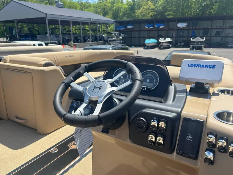 Slide: The Image of 2025 Harris Sunliner 230 SL boat dashboard with steering wheel and Lowrance navigation system. - 3