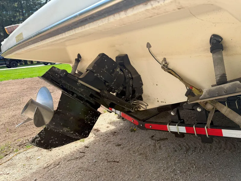 Slide: The Image of 1988 Slickcraft 268 SC boat stern with propeller and trailer, parked on gravel. - 11