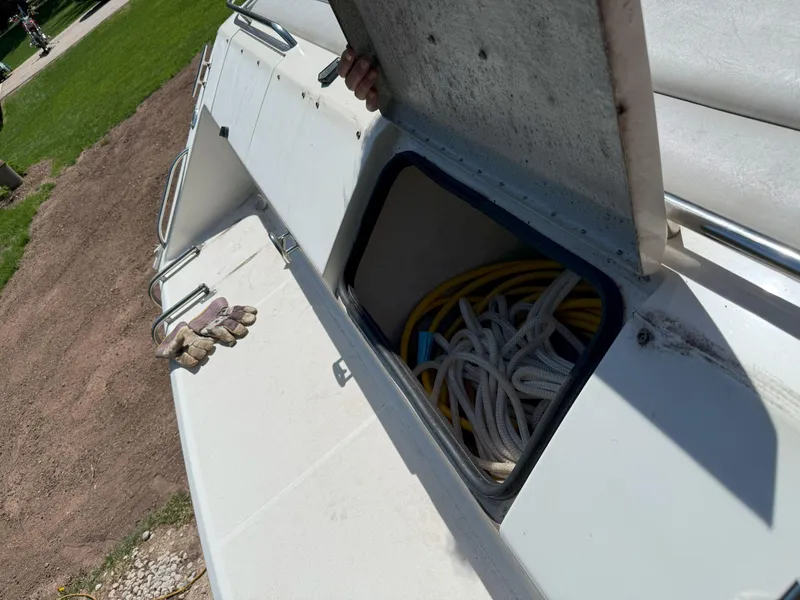 Slide: The Image of 1988 Slickcraft 268 SC boat storage compartment with ropes and gloves on deck. - 14