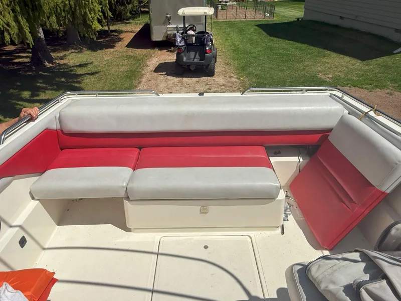 Slide: The Image of 1988 Slickcraft 268 SC boat interior with red and gray seating, parked on grass. - 17