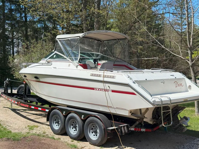 Slide: The Image of 1988 Slickcraft 268 SC boat on a trailer, surrounded by trees. - 2