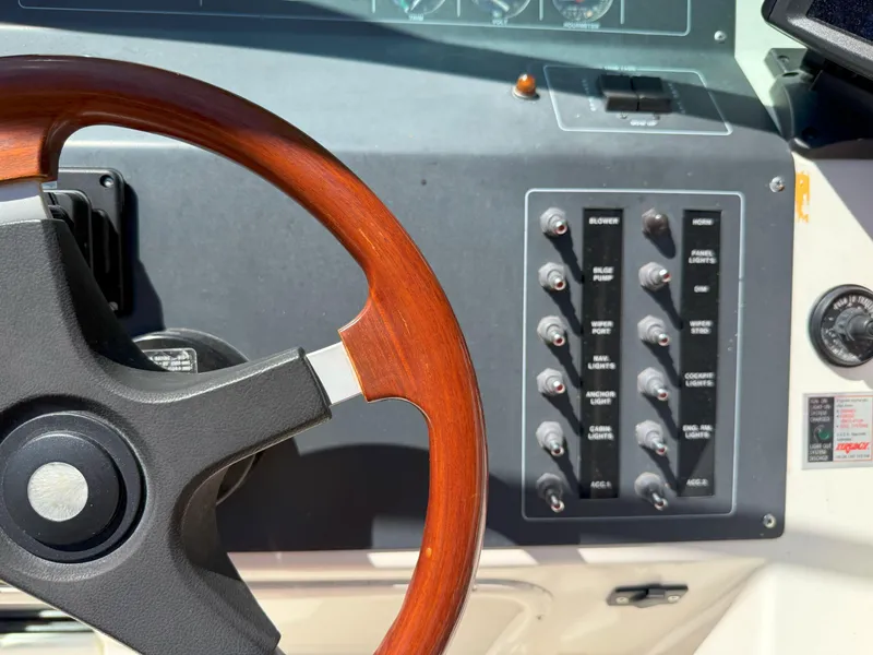 Slide: The Image of 1988 Slickcraft 268 SC boat dashboard with wooden steering wheel and control panel. - 25