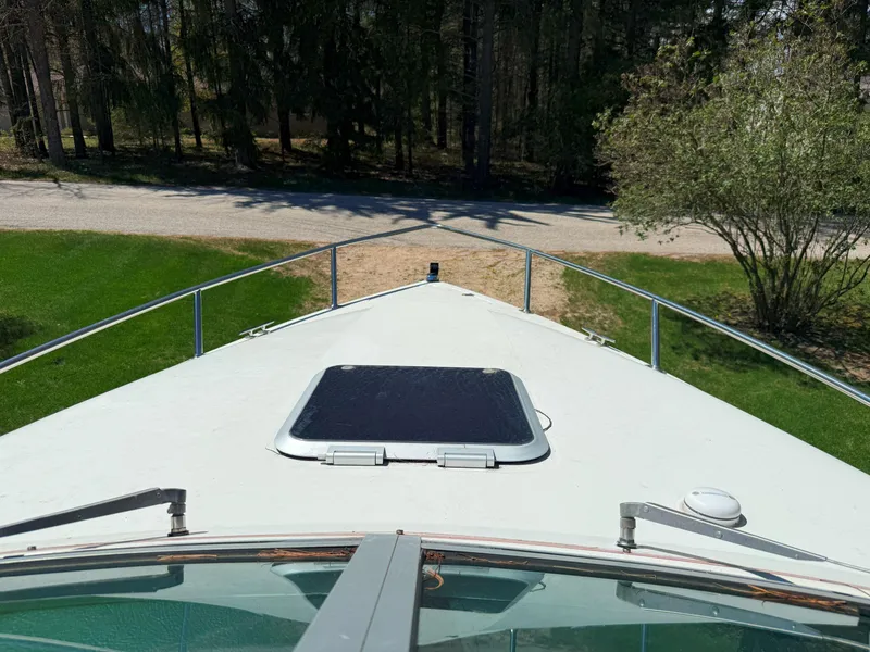Slide: The Image of 1988 Slickcraft 268 SC boat bow view with hatch, surrounded by greenery. - 27