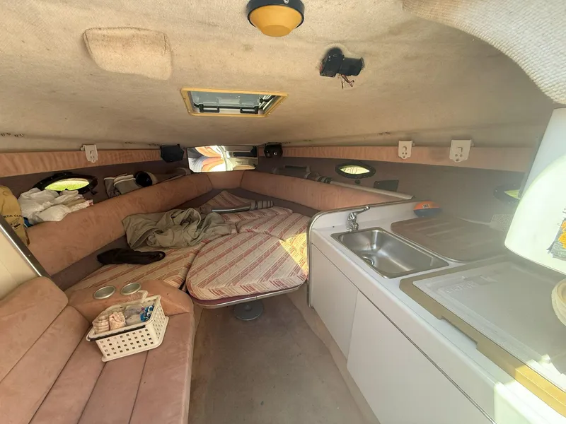 Slide: The Image of Interior of 1988 Slickcraft 268 SC boat with cozy seating and compact kitchen area. - 29