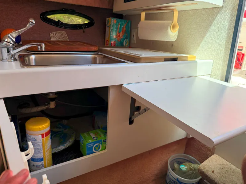 Slide: The Image of Compact kitchen area in a 1988 Slickcraft 268 SC boat with sink and storage. - 31