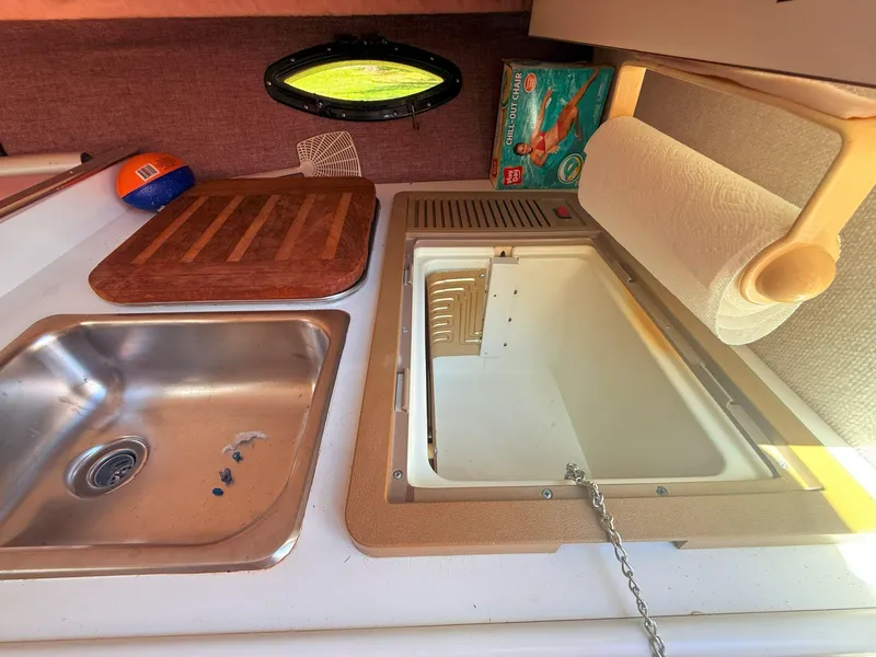 Slide: The Image of 1988 Slickcraft 268 SC boat interior with sink, cutting board, and paper towel holder. - 32