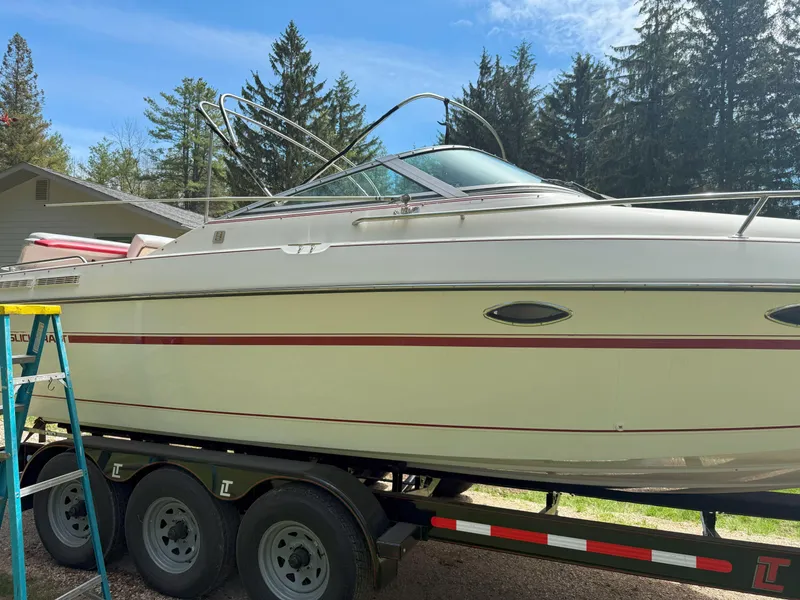 Slide: The Image of 1988 Slickcraft 268 SC boat on trailer, surrounded by trees and blue sky. - 5