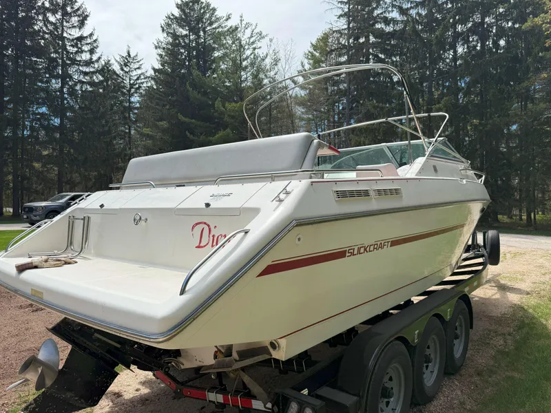 Slide: The Image of 1988 Slickcraft 268 SC boat on trailer, surrounded by trees. - 6