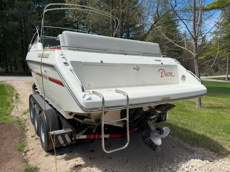 Slide: The Image of 1988 Slickcraft 268 SC boat on trailer, parked outdoors, rear view with ladder and propeller visible. - 8
