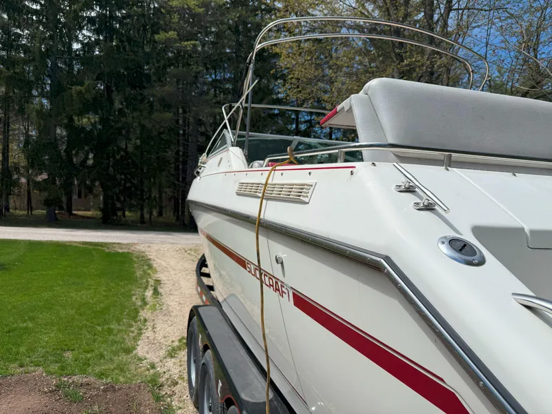 Slide: The Image of 1988 Slickcraft 268 SC boat on trailer, parked outdoors near trees. - 9