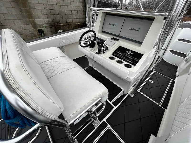 Slide: The Image of 2011 Fountain 38 CC Tournament Edition boat cockpit with Garmin navigation displays and white seating. - 22