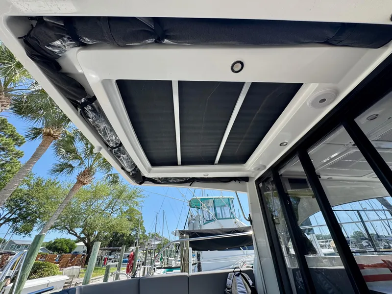 Slide: The Image of 2024 Beneteau Antares 11 boat interior with sunroof, docked at marina. - 13