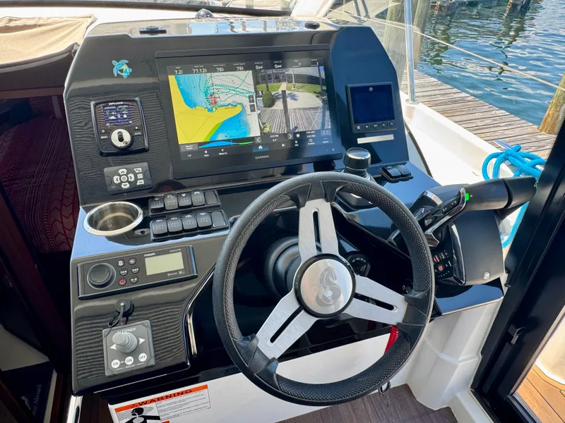 Slide: The Image of 2024 Beneteau Antares 11 helm with advanced navigation system and controls, dockside view. - 17