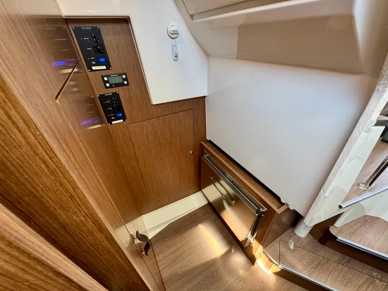 Slide: The Image of 2024 Beneteau Antares 11 interior with wood paneling and control panels. - 21