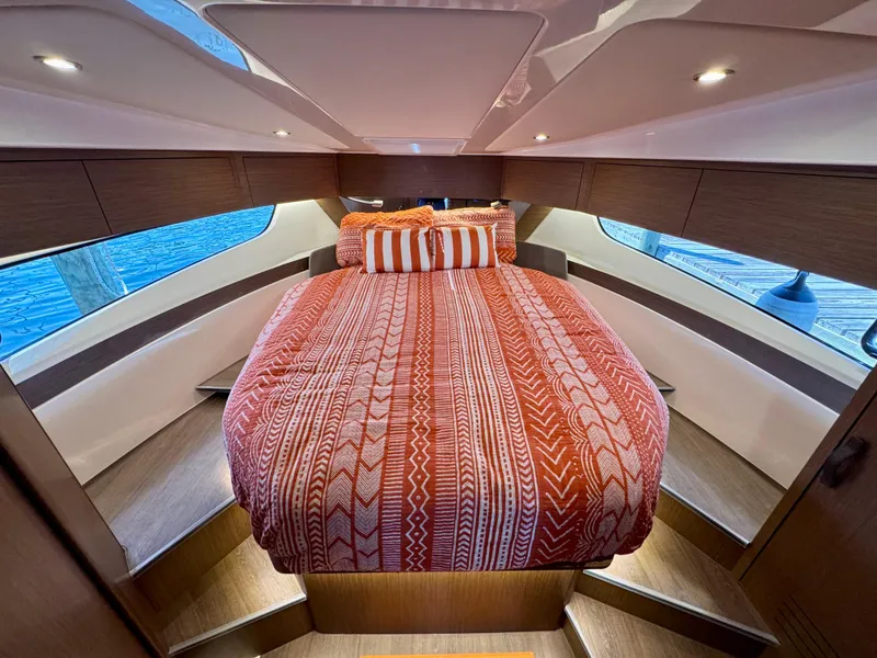 Slide: The Image of 2024 Beneteau Antares 11 cabin with cozy bed and stylish red bedding. - 22