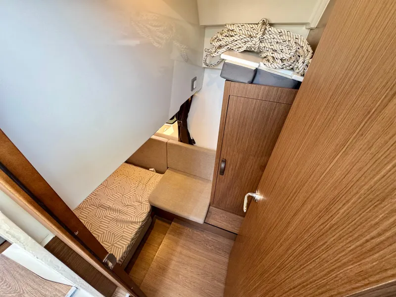 Slide: The Image of 2024 Beneteau Antares 11 cabin interior with wood finish and cozy bedding. - 28