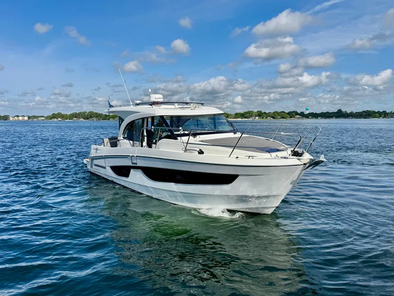 Slide: The Image of 2024 Beneteau Antares 11 cruising on a serene lake under a partly cloudy sky. - 3