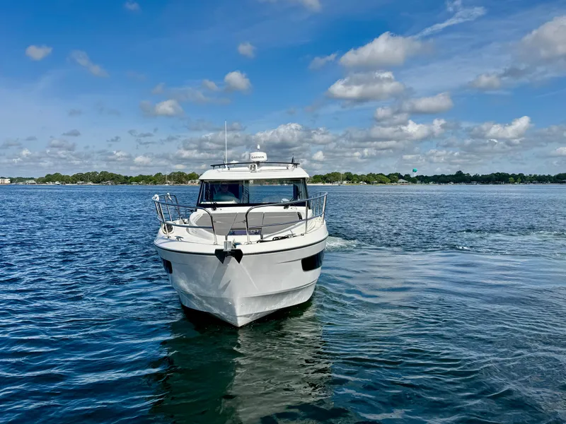 Slide: The Image of 2024 Beneteau Antares 11 boat on a calm lake under a partly cloudy sky. - 8